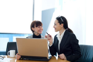 Two Women Sitting at a Table for Credit Counseling in Brooklyn, Farmingdale, Garden City, Medford, Middle Island, NY